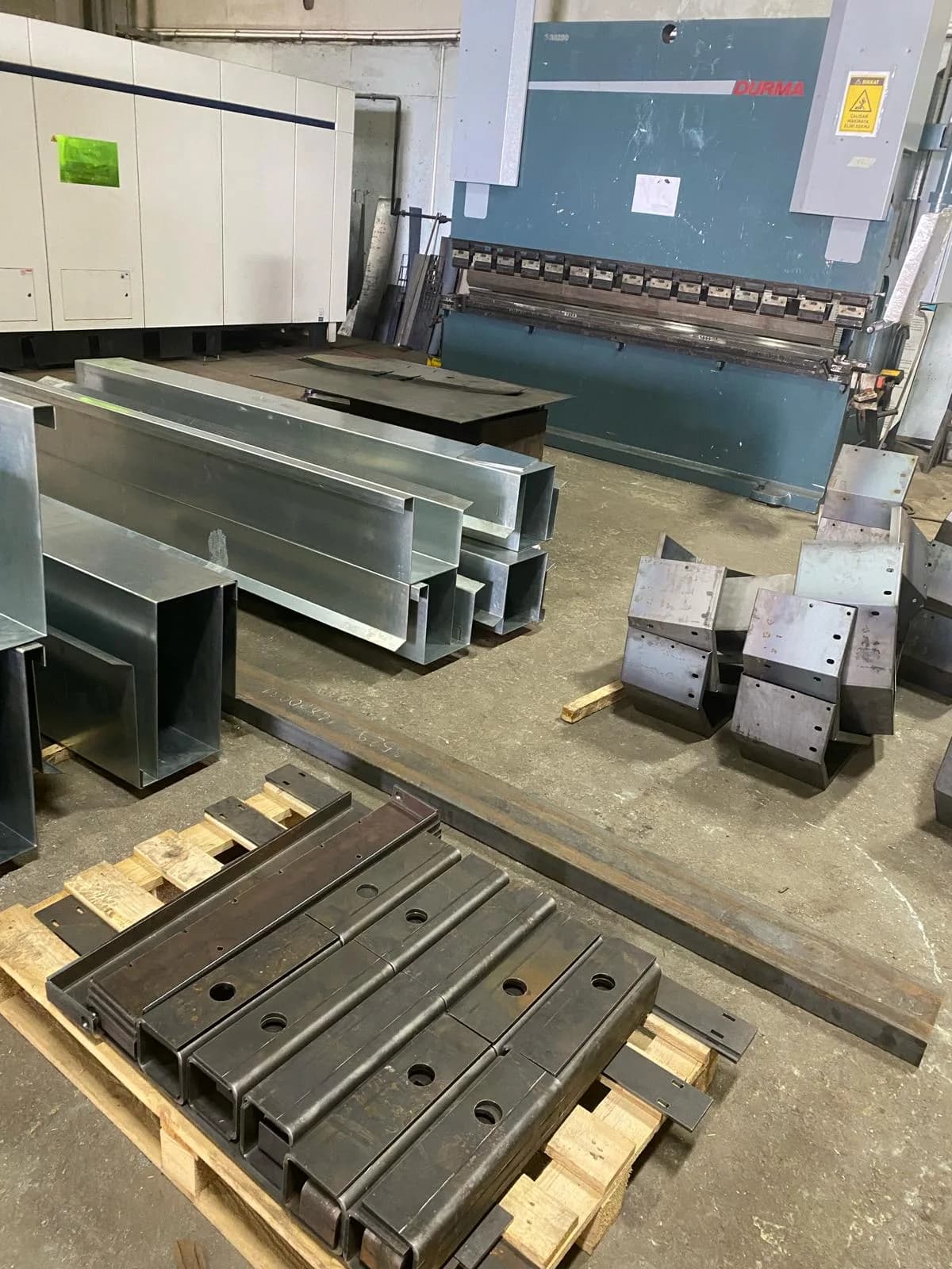 Long bent galvanised gutter profiles in front of the press brake