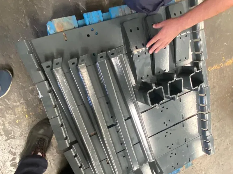 Powder-coated grey profiles and connection parts on a pallet, checked before dispatch