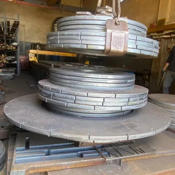Bundles of circular base plates and flanges lifted by crane